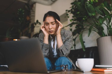 Netbook teknolojisi olan Asyalı bilişim uzmanı son teslim tarihi sırasında baş ağrısı hissetti. Uzaktan kumandalı kapalı alanda çalışıyor. Dizüstü bilgisayarı olan yorgun kadın programcı mesai sırasında yoruldu.