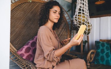 İnternet üzerindeki etki seminerinde teta bütünsel iyileşmenin ne olduğunu açıklayan kadın numerolog, beyaz kadın ağlardaki insanlara koçluk yapmak için akıllı telefon ön kamerasını kullanıyor.