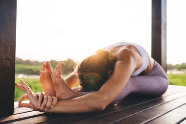 Sabahları Endonezya 'da egzersiz yapmak için uygun kadın vücut esnekliği, spor giyimli beyaz kadın Tayland' da pirinç tarlalarının yanındaki terasta yoga pratiği yapıyor.