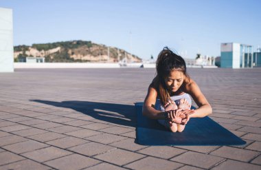 Esnek kadın yogi, şehir ortamında egzersiz yaparken yoga yapıyor, sağlıklı yaşam tarzının keyfini çıkarıyor, ince vücut şekilli genç Asyalı kadın, akrobik pilates yaparken kaslarını çalıştırıyor.