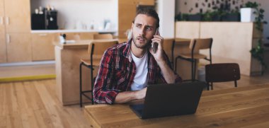 Laptop bilgisayarı olan kafası karışmış bir erkek cep telefonu uygulamasını kullanarak serbest yaşam tarzından bahsediyor. Dijital netbook ile ciddi grafik tasarımcısı ve danışmanlık konuşması yapıyor.