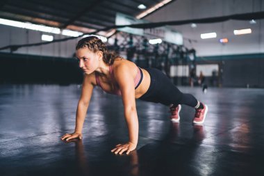 Deneyimli, beyaz, fit bir kız. Sabah antrenmanında zayıflıyor. Kollarını güçlendirmek için şınav çekiyor.