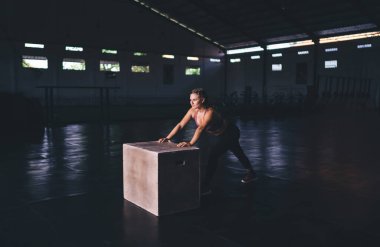 Aktif olarak giyinen beyaz kadın spor salonunda ısınma egzersizleri yapıyor. Spor stüdyosunda zayıflama egzersizi yaparken kas şekilli kararlı kadın kaslarını esnetiyor.