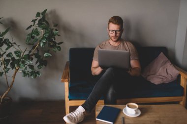Kızıl saçlı adam, kapalı bir ofiste dizüstü bilgisayarla serbest bir proje üzerinde çalışıyor. İnternet sitesinde internet defteriyle otururken dijital göçebe haberleri okuyor. Yetişkin öğrenci çevrimiçi öğreniyor