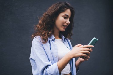 Genç milenyum kadını akıllı telefon uygulamasından mesaj yolluyor. Kopya alanı arka planında sosyal ağda kadın sohbeti. Nüfuz memuru cep telefonundan uyarı okuyor. Çevrimiçi ödeme ve web taraması