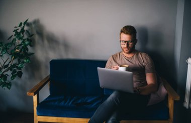 Kızıl saçlı adam, kapalı bir ofiste dizüstü bilgisayarla serbest bir proje üzerinde çalışıyor. İnternet sitesinde dijital göçebe haberleri okurken netbook 'ta oturup kahve içiyor. Öğrenci çevrimiçi öğrenimi