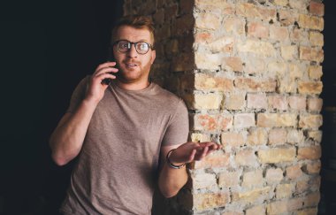 Şaşırmış bir adamın yarım boy cep telefonu konuşması. Beyaz, 30 yaşında, erkek, akıllı telefondan arıyor.