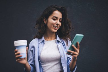 Genç milenyum kadını akıllı telefon uygulamasından mesaj yolluyor. Kopya alanı arka planında sosyal ağda kadın sohbeti. Nüfuz memuru cep telefonundan uyarı okuyor. Çevrimiçi ödeme ve web taraması