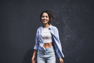 Yarı boy, modaya uygun giyinmiş, tasasız ve neşeli bir kadın portresi. Reklam için alanı kopyalayın. Kot giysili genç kız.