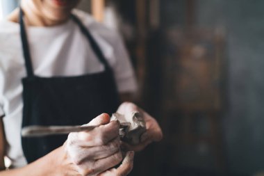 Sanat atölyesinde seramik çömlek döşeyen 50 yaşındaki kadın resminin kesilmiş hali. Küçük işletmeler ve girişimcilik. Ev hobisi, eğlence ve eğlence. İş önlüğü giyen kadın.