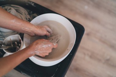 Sanat atölyesindeki seramik çömlek kalıbını çıkardıktan sonra kadın yıkama aletinin kısmi görüntüsü. Küçük işletme ve girişimcilik kavramı. Ev hobisi, eğlence ve eğlence. Üst görünüm