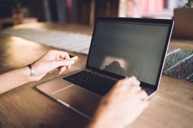 Modern dizüstü bilgisayar teknolojisinde içerik yaratmak için dizüstü bilgisayar kullanan tanınmayan erkek içerik yöneticisinin kırpılmış görüntüsü, netbook teknolojisiyle internet bilgilerini arayan erkek bilişim uzmanı