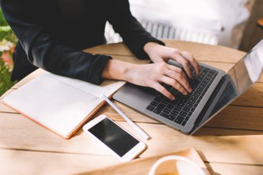 Kesilmiş kadın girişimci, internet sayfası klavyesinde yazan tanınmayan bir kadın, kafenin iç kısımlarında çalışarak gazetecilik yayınını düzenlemek için dizüstü bilgisayar uygulaması kullanıyor.