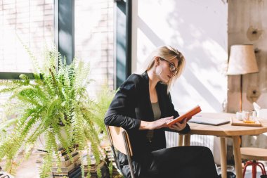Optik gözlüklü beyaz bir kadın boş zamanlarında ilginç edebiyat kitapları okuyor. Kafe iç kısımlarında geçirilen ders kitaplarındaki bilgileri analiz ediyor.