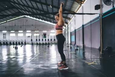 Kettlebell 'li mutlu bir kadın ağırlık kaldırma sırasında vücut kaslarını çalıştırıyor, halterli gülümseyen bir kadın tonusta vücut şeklini korumak için egzersiz yapıyor - sağlıklı yaşam tarzı.