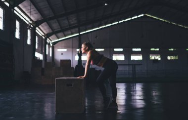 Aktif giyimli güçlü beyaz kadın spor salonunda aktif kardiyo çalışması yapıyor. Zayıf genç kadın kutu ekipmanıyla iyi sonuçlara ve fitness hedeflerine ulaşıyor. Sağlıklı yaşam tarzı ve canlılık kavramı.