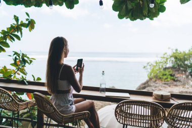 Tayland 'a seyahat ederken, resmi deniz kenarında çekilen, günlük kıyafetleri içinde, isimsiz bir kadının arka plan görüntüsü.