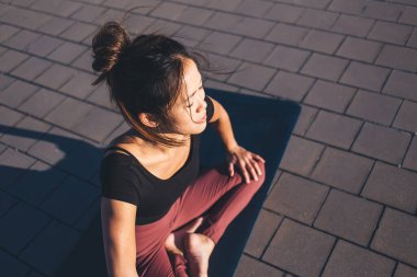 Sabah yogası sırasında harmoni ve meditasyon eğitimi, Asya 'da vücut konsantrasyonu egzersizi yapmak için Hatha antrenmanı sırasında Lotus pozu veren sportif giyinmiş Asyalı kadın yogi.