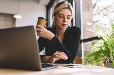 Modern dizüstü bilgisayarı olan Millennial Woman, kahve molası sırasında akıllı telefon cihazından cep telefonundan müzik listesi seçen kulaklıklı mutlu bir kadın için e-posta aldı.