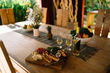Atıştırmalık yemeğe ve alkole odaklanın. Masada beyaz şarap, başlangıç olarak sandviç ve sebzeler. Yemekte ya da öğle yemeğinde atıştırmak için.