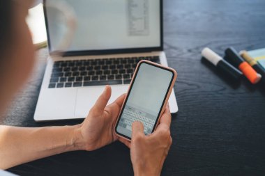 İnternette iş projesinde çalışırken bilgisayarlı ve telefonunda fotokopi alanı olan yüksek açılı anonim kadın.
