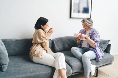 Mutlu, olgun bir anne ve genç kızın birbirlerine sevgisini hediye olarak göstermeleri ve evdeki oturma odasında birlikte vakit geçirmeleri.