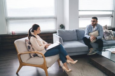 Kadın psikoloğun sorular sorup notlar aldığına ve depresyondaki erkek müşterinin rahat koltukta otururken cevap verdiğine şahit oldum.