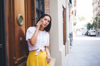 Turistik seyahat sırasında akıllı telefon iletişimi için 4G kablosuz bağlantı kuran ilginç kadın kullanıcı, şehirdeki mobil teknoloji ile konuşan genç beyaz kadın