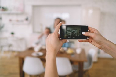 Sabah saatlerinde modern mutfaktaki insanların cep telefonuyla yatay fotoğraf çeken...