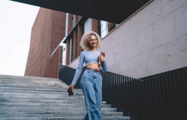 Düşük açılı, neşeli, pozitif bir kız öğrenci. Günlük giysiler içinde. Gülümseyen ve yüzünü çeviren.