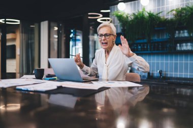 Sinirli kıdemli girişimci, çalışanlarıyla video konferansı yapıyor. Modern ofiste konuşurken bağırıp çağırma sorunlarına çok kızıyor.