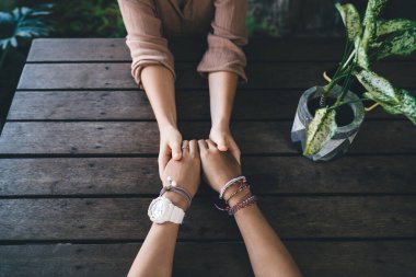 Randevu sırasında el ele tutuşan, iletişim kuran, konuşan, ruhsal yardım sırasında birlikte dua eden ve destek için ritüel tutan kadınlar.