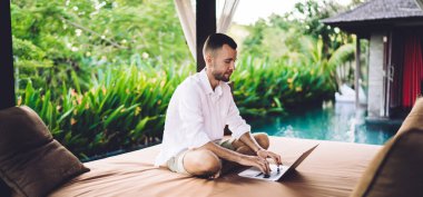 Sosyal medyada paylaşım için web metni ve içeriği oluşturan Millennial serbest metin yazarı, rahat terasta iş yaparken veri kodunu düzenleyen yetenekli programcı