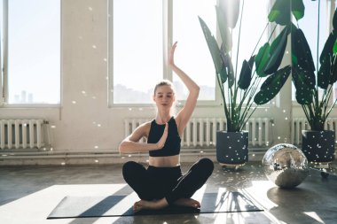 Padmasana pozunda dinlenen ve yoga dersinde düşünceli ve meditasyon yaparken ellerini namaste Mudra 'ya çeviren zayıf bir kadın vücudu.