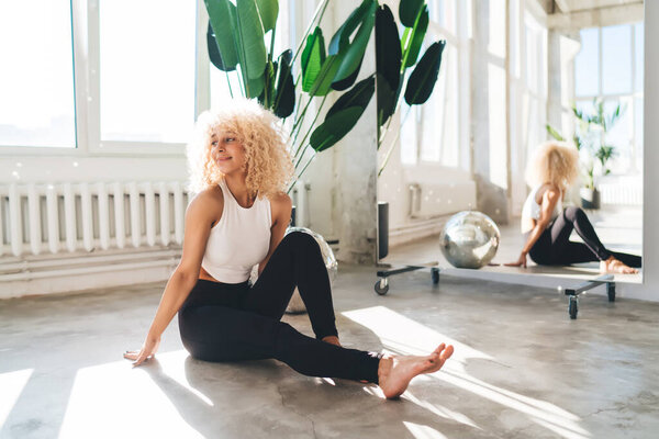Side View Slim Female Curly Hair Activewear Sitting Floor Dancing Stock Image