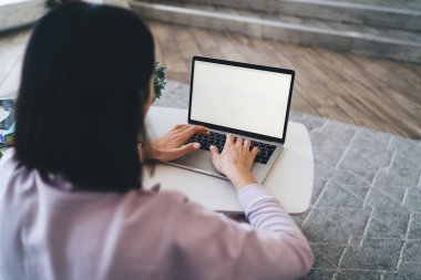 Masada oturan ve boş ekranlı netbook kullanan, gündüzleri serbest çalışan isimsiz bir kadından.