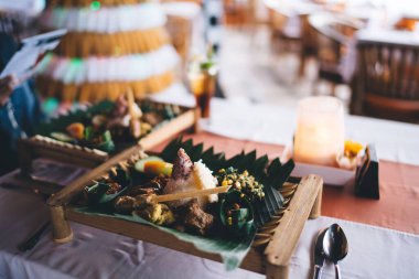 Ahşap tabağa konmuş pirinç ve yosunlu lezzetli ve sağlıklı yemekler ve masada sebzelerle servis edilir.