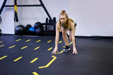 Spor kıyafetleri ve spor ayakkabıları giymiş, spor salonunda spor yaparken dağ tırmanışı egzersizi yapan güçlü bayan sporculardan oluşan bir vücut.