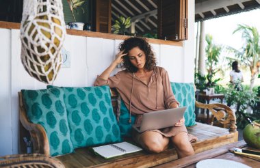 Milenyum dijital göçebe planlama içeriği kafede serbest yaşam tarzını korurken. İnternet üzerinden video izlemek için netbook bilgisayarı kullanan yetenekli kadın metin yazarı