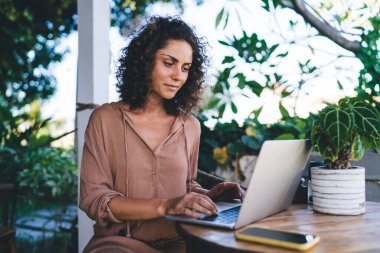 Genç bayan grafik tasarımcısı, dijital dizüstü bilgisayarda 4G kablosuz ağ oluşturmak için internet sitesi oluştururken, modern ağ oluşturma konusunda yetenekli blogger web sayfası