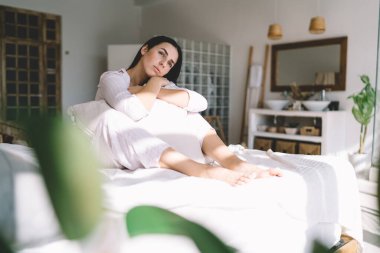 Dalgın genç bir kadın gözlerini kaçırıyor ve parlak bir sabah boyunca hayal kuruyor. Yastıklara yaslanıyor ve şık bir yatak odasında rahat bir yatakta dinleniyor.