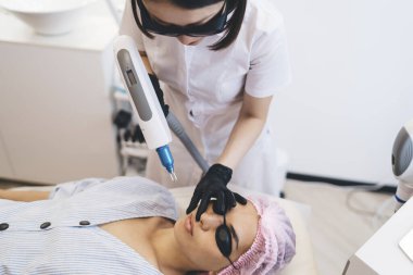 Güzellik kliniğindeki profesyonel terapist yüzünden yüz kıllarını aldırma prosedürü uyguluyor.