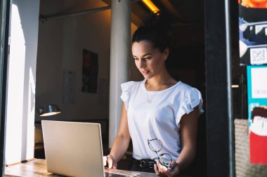 Netbook cihazlı akıllı kadın bilişim uzmanı sosyal ağlara göz atarken web bilgi yayını arıyor, milenyum kadını dijital laptop uygulaması ile web grafik tasarımı yaratıyor