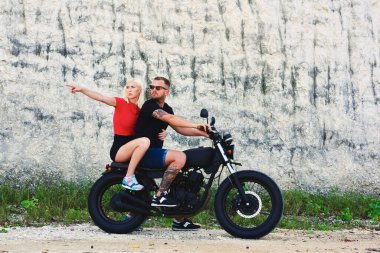 Erkek ve dişi turist, motosiklet gezisi sırasında doğru yolu arıyorlar. Çekici sarışın hippi kız, motosiklet sürerken motosikletli erkek arkadaşıyla göz teması kuruyor.