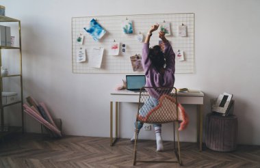 Genç milenyum kadın serbest çalışan dizüstü bilgisayarla masada oturuyor, iş projesinin tamamlanışını kutluyor. Rahat kız öğrenci internetten öğrenmeyi uzaktan eğitim için netbook kullanırken bitirir