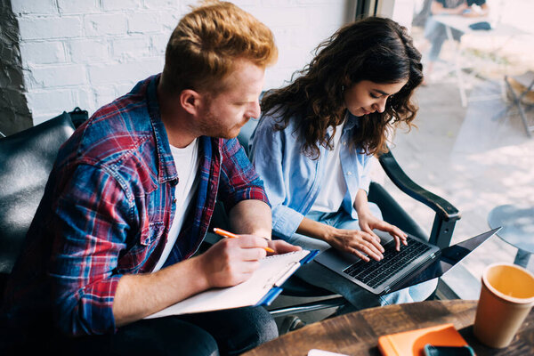 Кавказские разработчики программного обеспечения анализируя программный код данных во время совместной совместной встречи, молодой человек и женщина смотрят онлайн видео вебинара во время веб-чата по современной технологии нетбуков