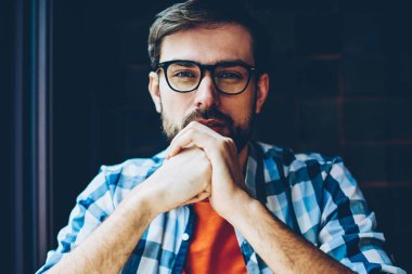 Kameraya bakarak sağlamak gözleri koruma için optik gözlük sakallı genç adam yarım uzunluk portre. Yakışıklı erkek blogger ciddi bir yüz ile şık casual gömlek giymiş