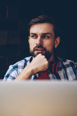 Düşünceli sakallı erkek o serbest modern dizüstü bilgisayar, kablosuz 4 g ile çalışma programı geliştirilmesi üzerinde düşünme profesyonel internet. Yayın için fikirler üzerinde durulması şaşkın genç adam