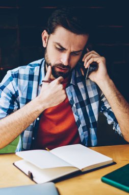 Dalgın sakallı hippi adam akıllı planı üzerinde düşünürken arama. Telefonla kafede oturan telefon görüşmesi sırasında istemci ve çözme sorunları ile konuşan genç adam konsantre