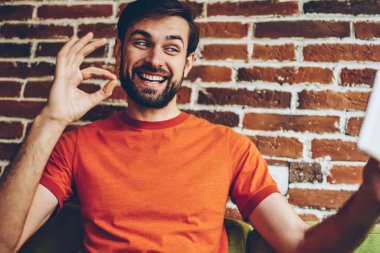 Neşeli sakallı adam el işareti video seslenmek yolu ile iletişim sırasında modern Tablet ön kamera tamam. Fotoğraf Dijital Dokunmatik ped cihaz üzerinde yapım başarılı hipster adam bağlı 4 g için Internet